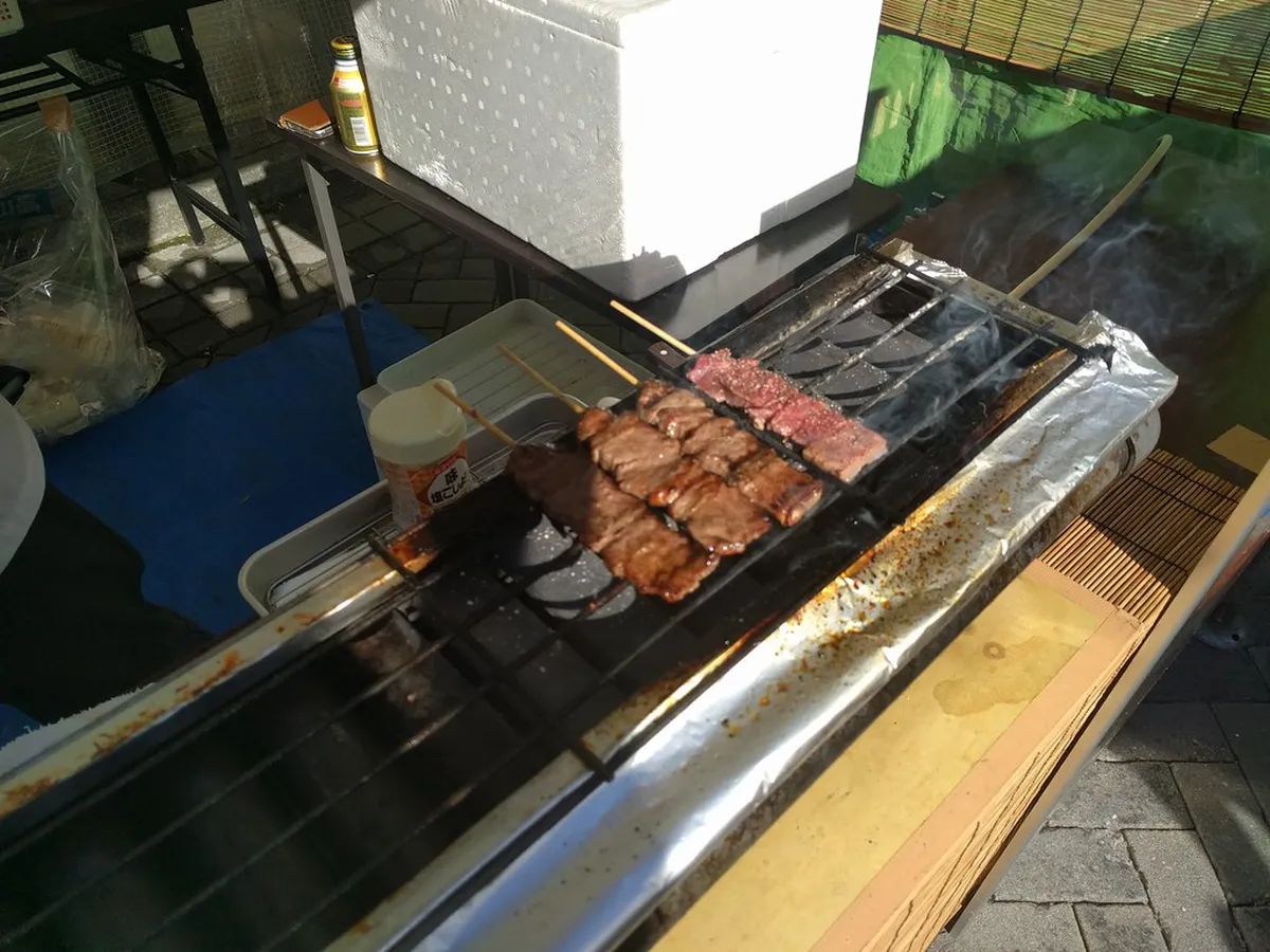 Hida beef nigiri sushi and street snacks being prepared at a stall in Takayama old town Japan