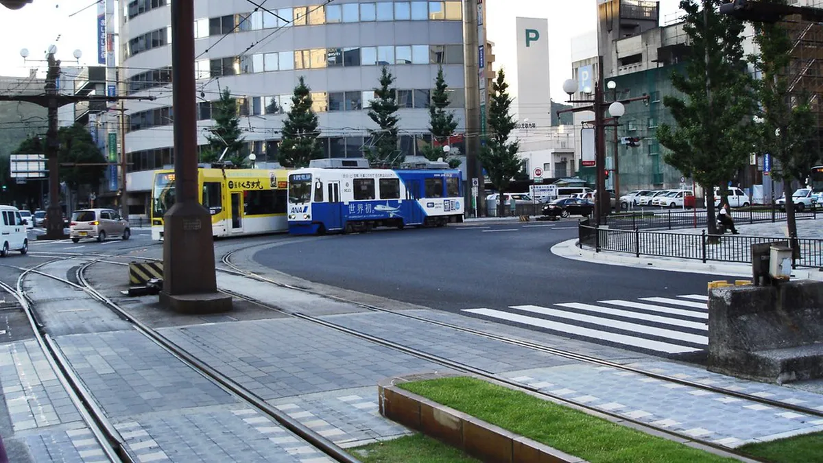 Historic Kagoshima city tram passing through the central shopping district on its route connecting Tenmonkan and Kagoshima Station in Japan