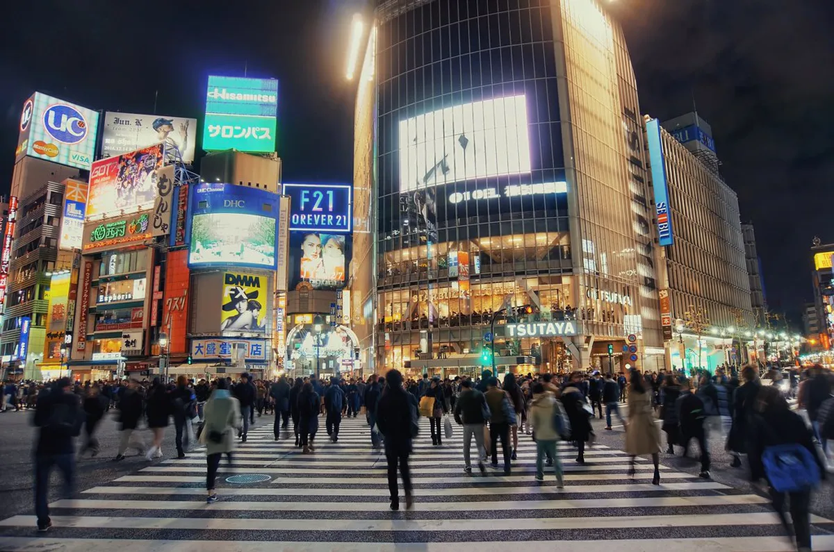 Shibuya crossing and entertainment district lit up at night with crowds in Tokyo, Japan