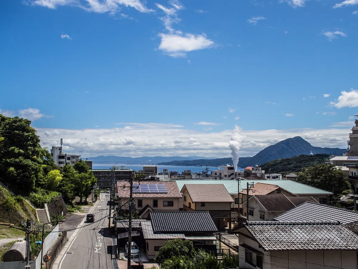 Beppu city steam rising from hot spring vents across the hillside cityscape in Kyushu, Japan