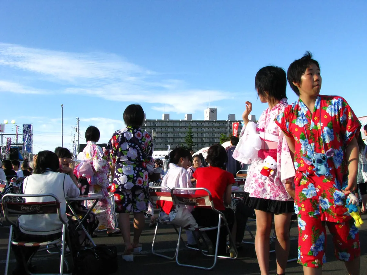 Festival-goers wearing colorful yukata robes at a traditional Japanese summer celebration