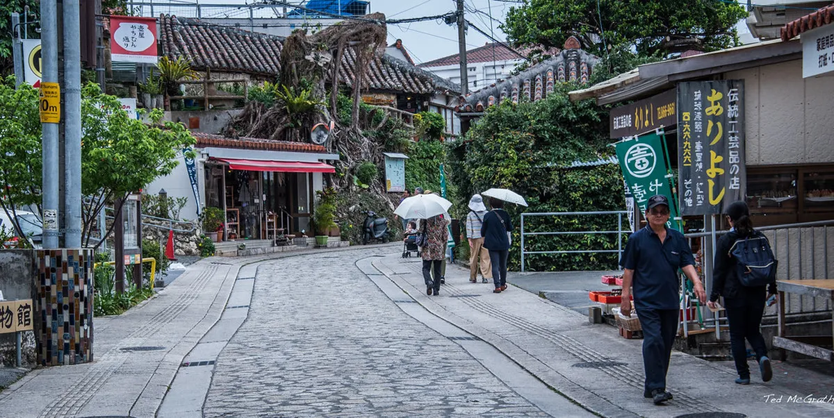 Limestone-paved cobblestone alley in the Tsuboya Pottery District of Naha, Okinawa, lined with traditional workshops
