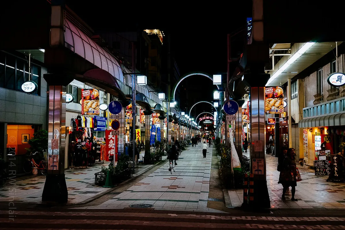 Tsutenkaku Tower rising above the retro Shinsekai neighborhood streets filled with restaurants and signs, Osaka Japan