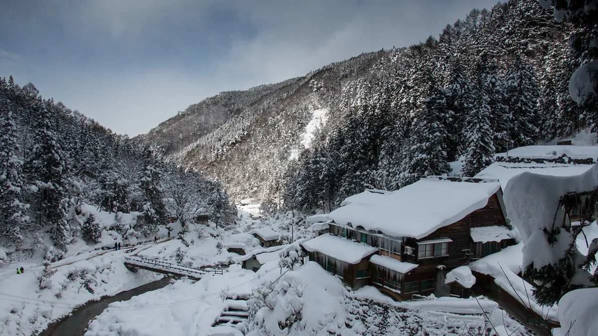 Steaming hot spring pool surrounded by snow at a Japanese onsen in Hokkaido