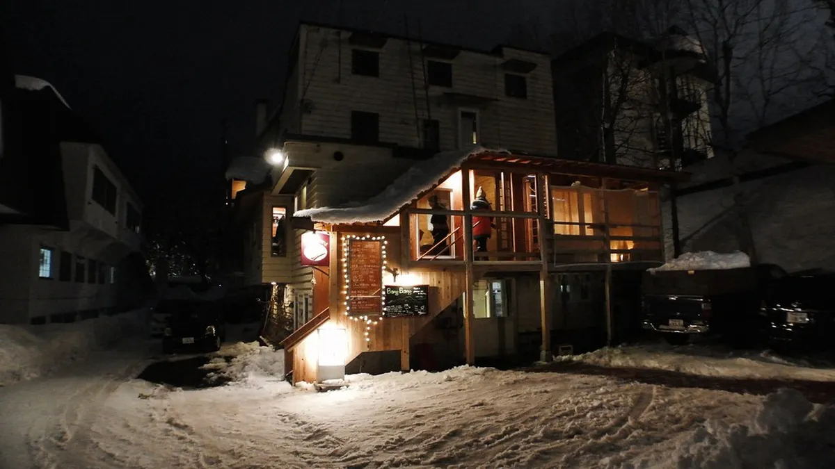 Snow-covered resort buildings and lodge structures nestled in the Niseko Annupuri mountains