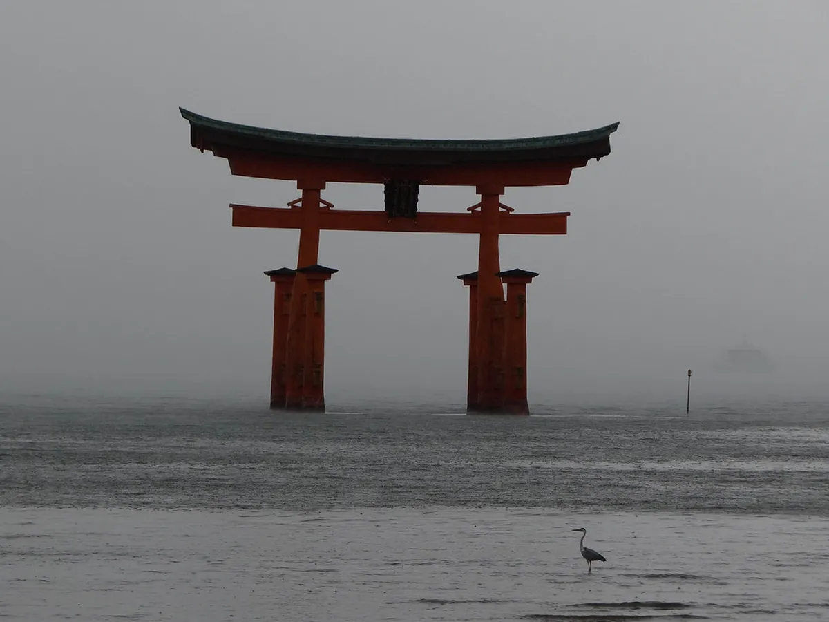 Itsukushima Shrine torii gate rising from the sea at high tide on Miyajima Island, Japan