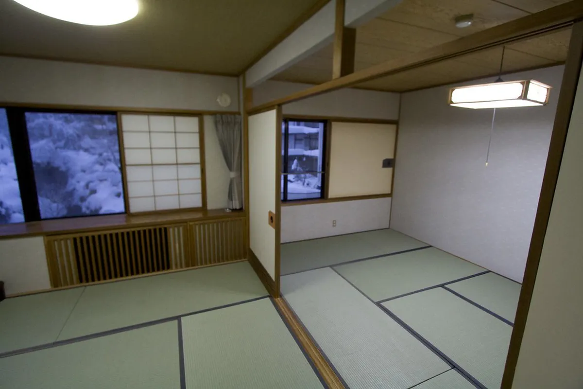 Steaming outdoor onsen bath surrounded by natural stone in a Takayama mountain ryokan, Japan