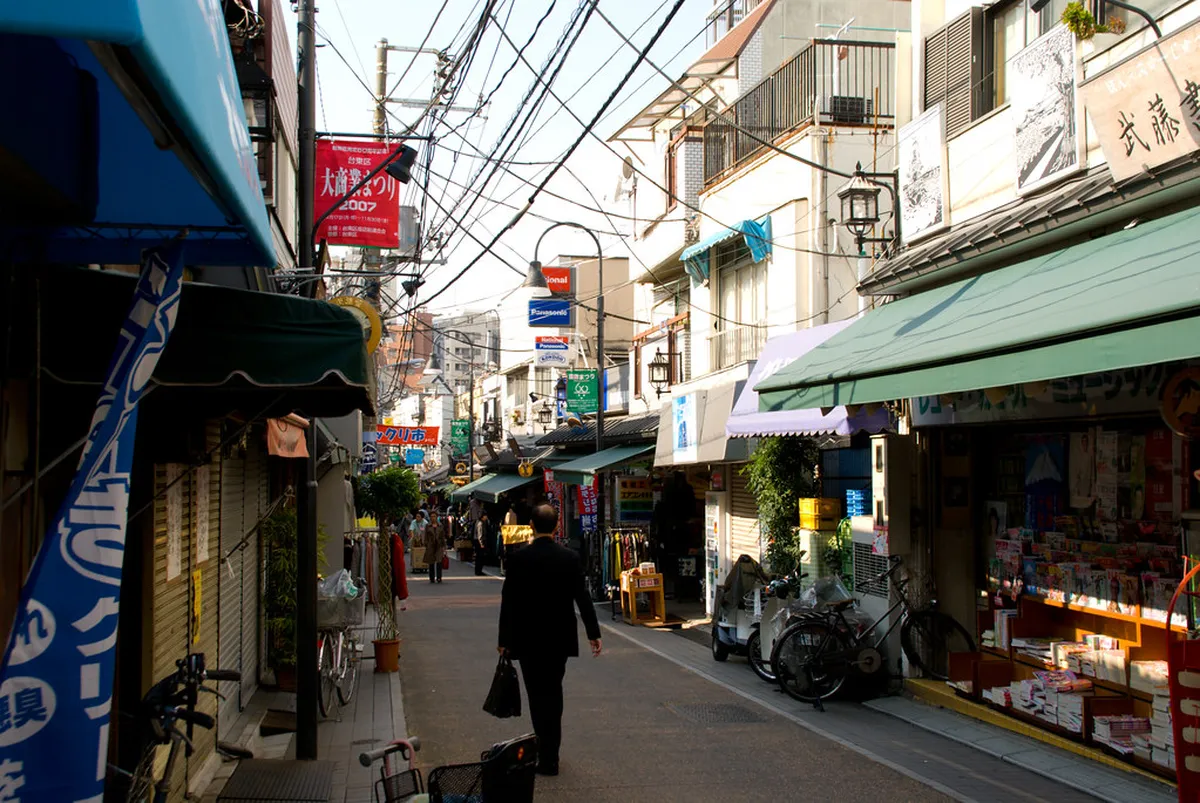 Yanaka Ginza shopping street in Tokyo lined with small traditional shops and lanterns under a clear sky