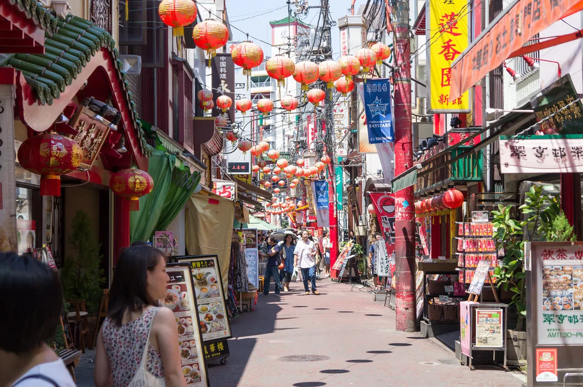 Yokohama Chinatown street food vendors offering steamed buns and dumplings along the busy market street in Japan