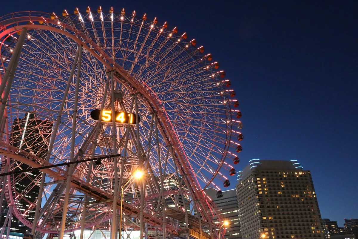 Cosmo Clock 21 Ferris wheel lit up at night with Minato Mirai skyline reflected in Yokohama harbor, Japan