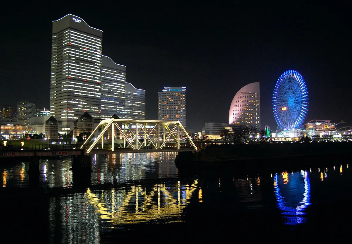 Yokohama Minato Mirai waterfront illuminated at night with skyscrapers and harbor lights reflecting on the bay