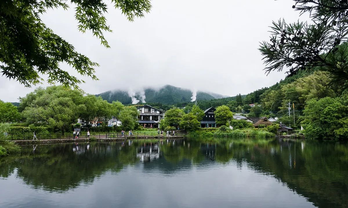 Early morning mist drifting across Lake Kinrin with Mount Yufu in the background in Yufuin Japan