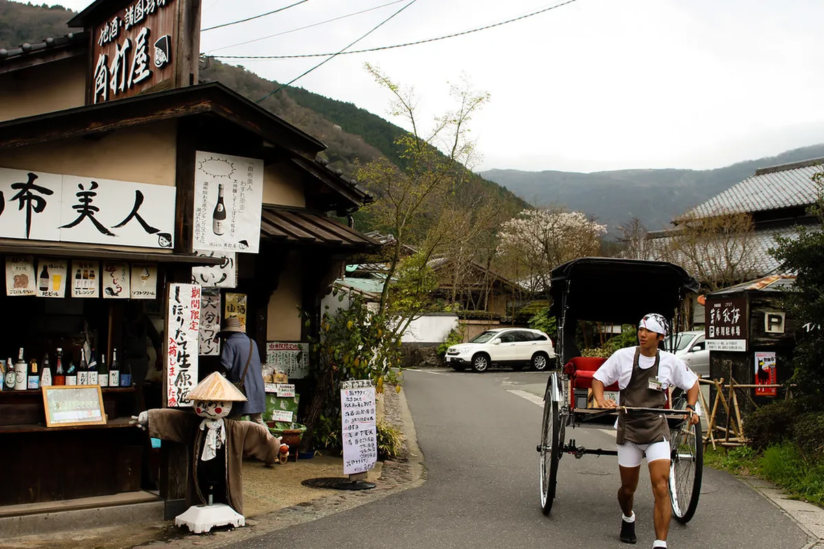 Traditional thatched-roof buildings and hot spring mist in the historic onsen town of Yufuin Japan