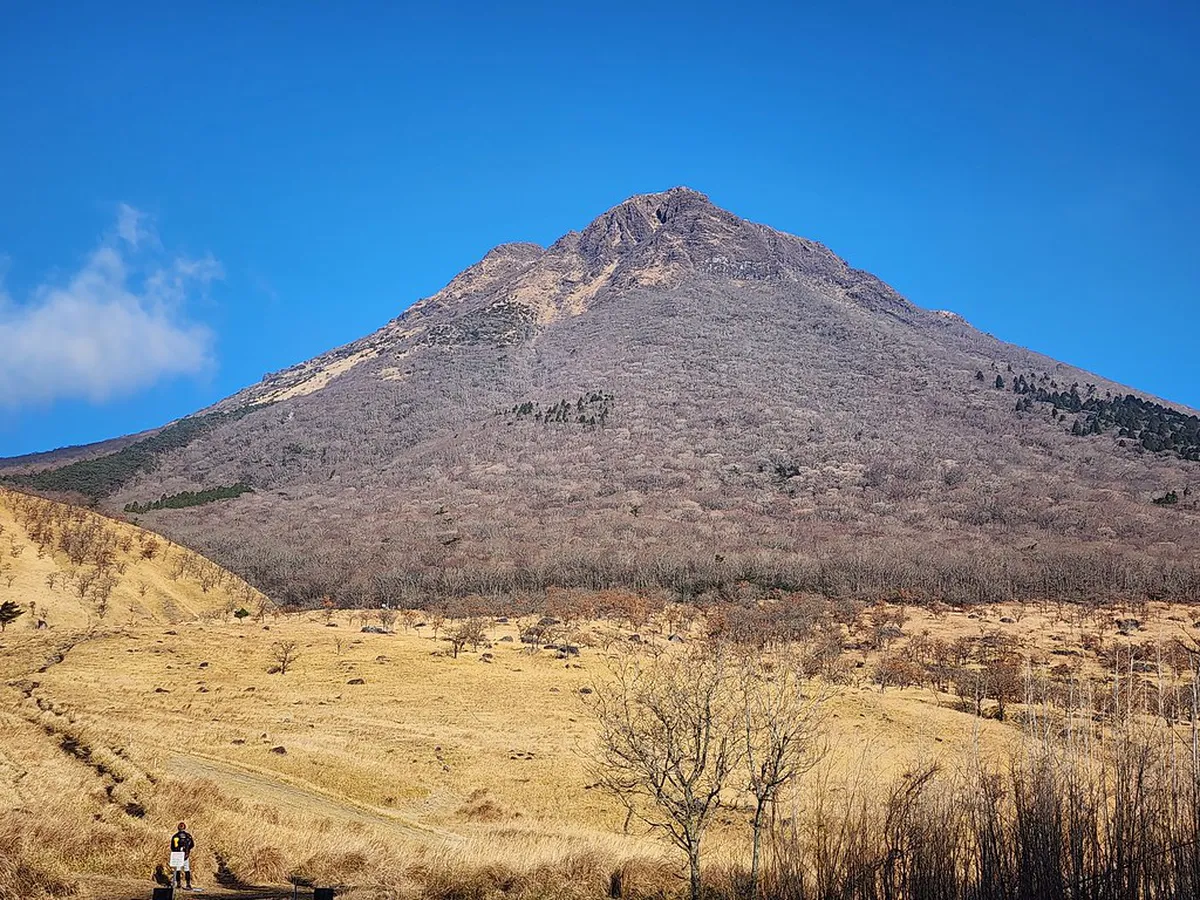 Twin volcanic peaks of Mount Yufu rising above the Yufuin valley floor in Oita Prefecture Japan