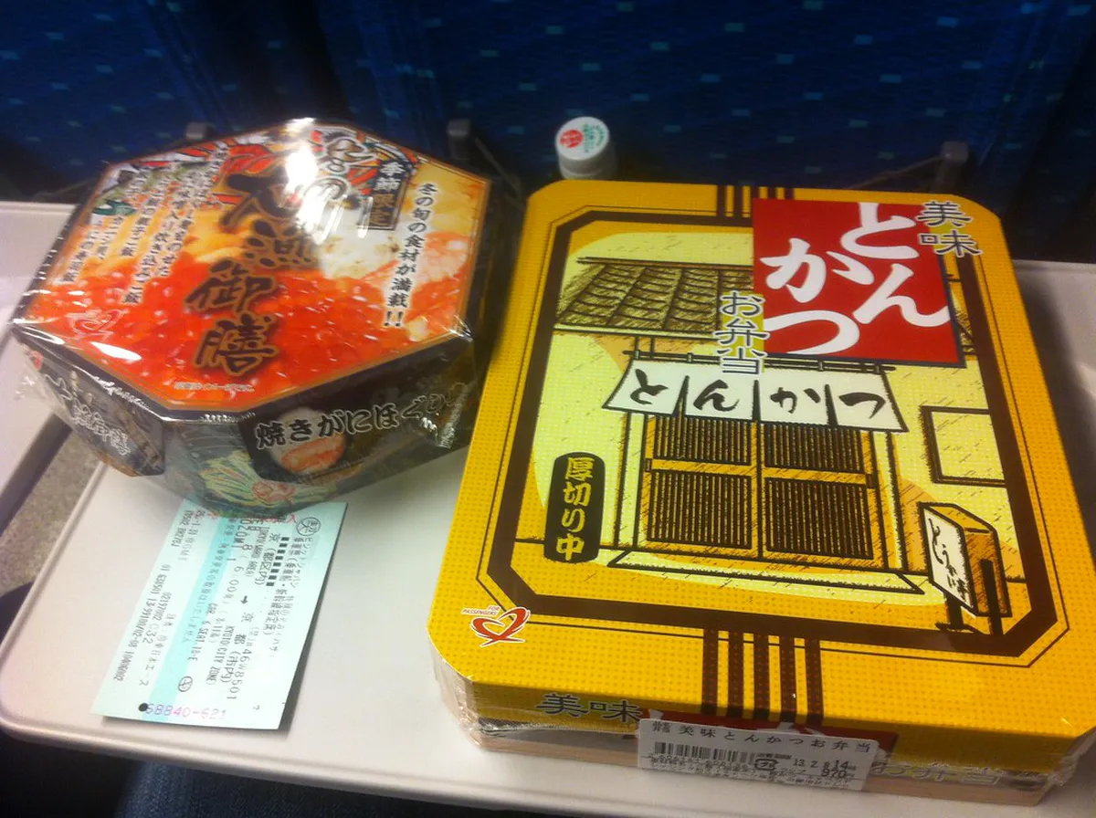 Traditional Japanese bento box with seasonal ingredients and local delicacies served on a scenic train in Japan