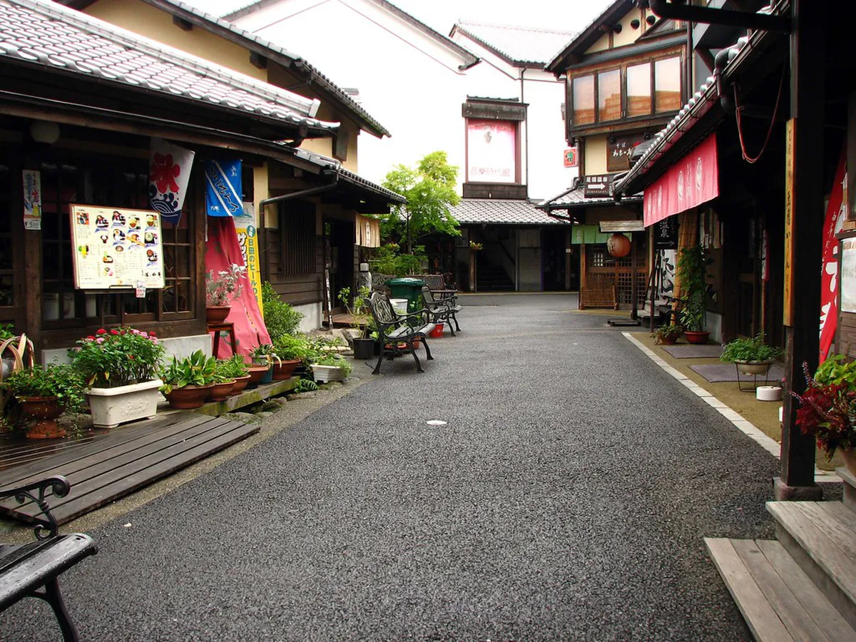 Yunotsubo shopping street in Yufuin with boutique stores and craft shops leading toward Mount Yufu Japan
